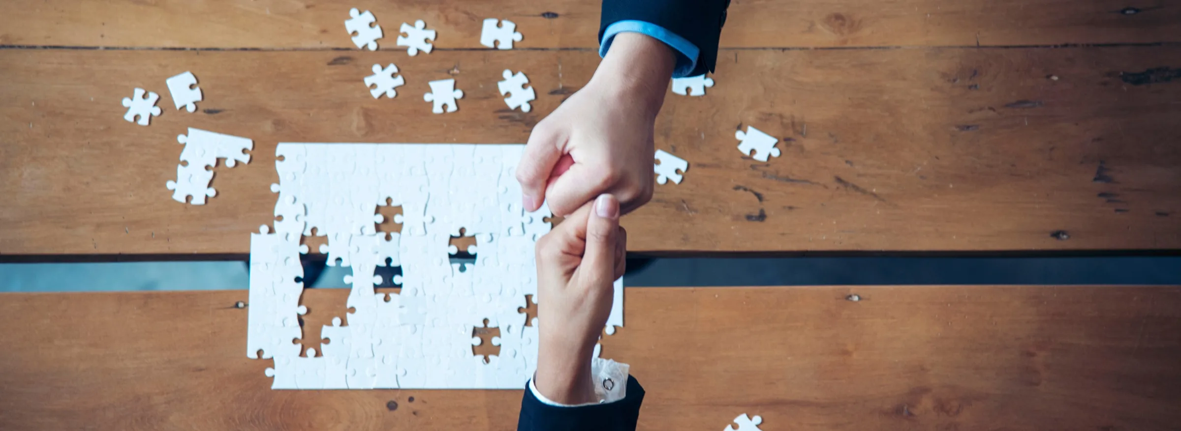 Two people connecting puzzle pieces as a symbol of neuropsychological support and clarity